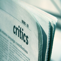 The corner of a newspaper with the word 'critics' printed on it.